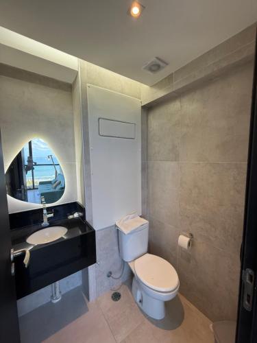 a bathroom with a toilet and a sink at Beach Flats Barra Home Stay By Flatbpaiva in Recife