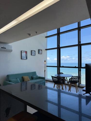 a living room with a couch and a table at Beach Flats Barra Home Stay By Flatbpaiva in Recife