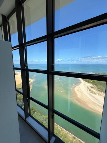 a view of the ocean from a window at Beach Flats Barra Home Stay By Flatbpaiva in Recife