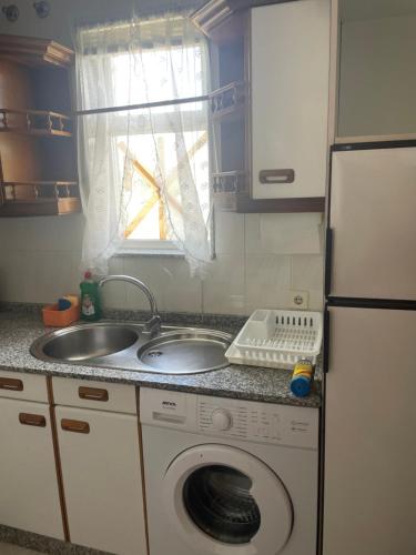 a kitchen with a washing machine and a sink at Piso acogedor con vistas in Val do Dubra