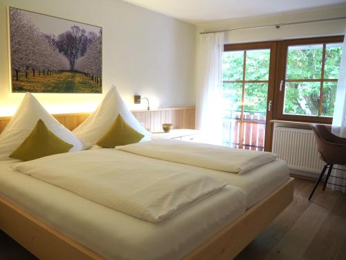 a large white bed in a room with a window at Schnurrenhof in Seebach