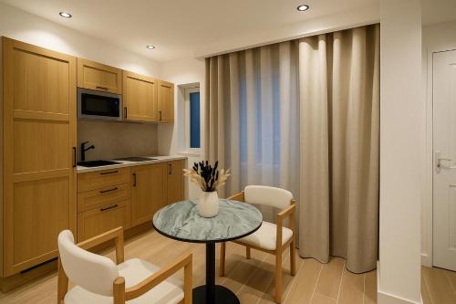 une cuisine avec une table et des chaises dans une pièce dans l'établissement Chic Studio Charonne, Haut-Marais, à Paris