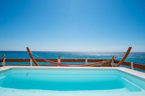 a swimming pool with the ocean in the background at Villa Renata & Villa Filippos with private Plunge Pool by Konnect in Agios Gordios