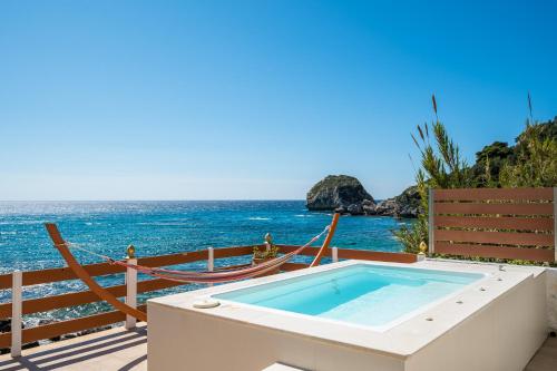 a hot tub on a deck overlooking the ocean at Villa Renata & Villa Filippos with private Plunge Pool by Konnect in Agios Gordios