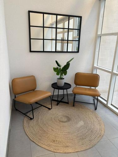 two chairs and a table in a room with a rug at Moderno Estudio en Osorno Full Equipado in Osorno