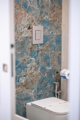 a bathroom with a toilet and a stone wall at Leone Camere D'autore - Rooftop Prince Centro Storico in Naples