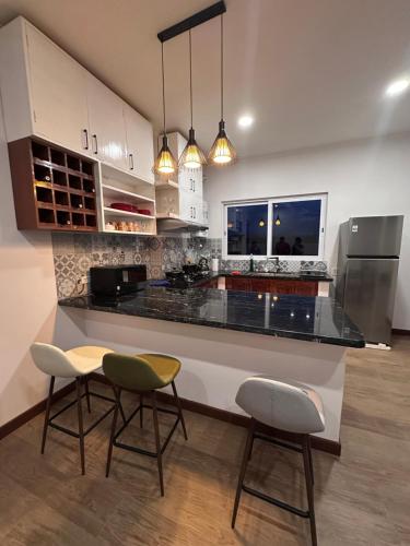 a kitchen with a counter and two stools at Acogedor departamento de 2 dormitorios in Tarija
