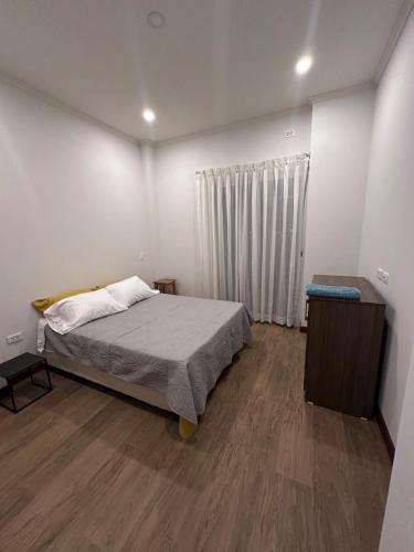 a bedroom with a bed and a dresser in it at Acogedor departamento de 2 dormitorios in Tarija