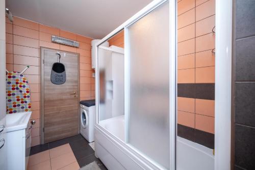 a bathroom with a shower and a washing machine at Apartment ŽNJAN in Split