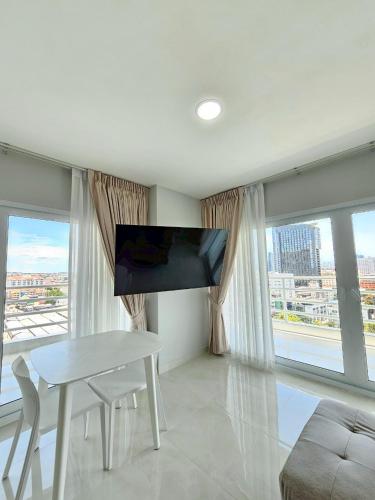 a living room with a table and a flat screen tv at View Talay6 by Blue Ocean Suite in Pattaya Central