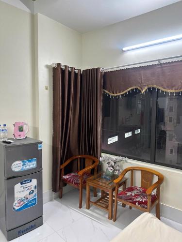 a room with two chairs and a table and a window at Khách Sạn Trang Thư in Quang Ngai