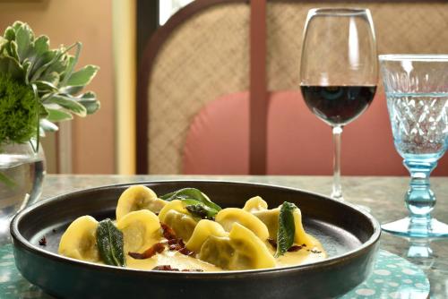 a bowl of pasta and a glass of wine on a table at Grand Hotel Savoia in Genova