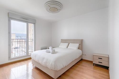une chambre blanche avec un lit blanc et une fenêtre dans l'établissement Saint Denis Leon Nozal Magnifique Apartment 5P, à Saint-Denis