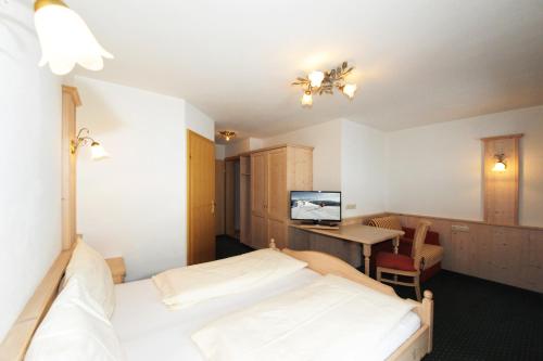 a bedroom with a bed and a desk with a computer at Riederhof in Leogang