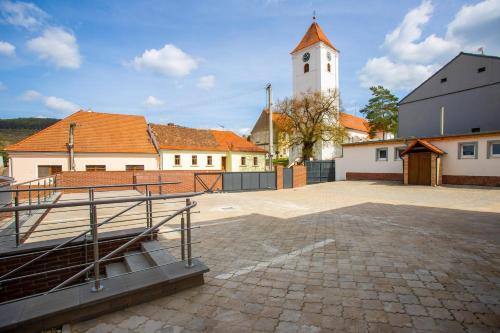 a church with a clock tower in a courtyard at Amenity Apartmány Perná in Perná