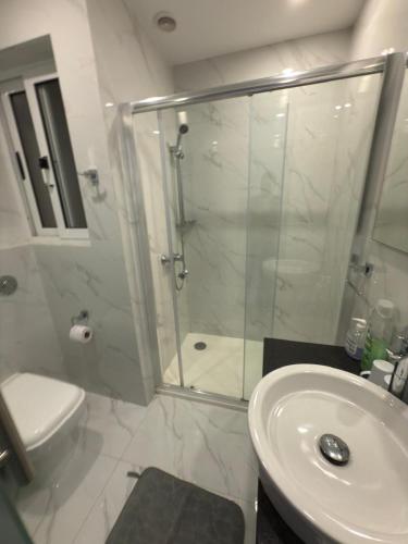 a bathroom with a shower and a toilet and a sink at The Urban Suites in Il-Gżira