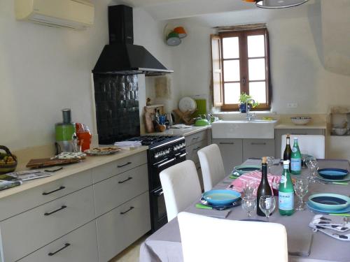 une cuisine avec une table et une cuisinière four supérieur dans l'établissement Charming House with Courtyard Garden and Views, à La Celle-sous-Gouzon