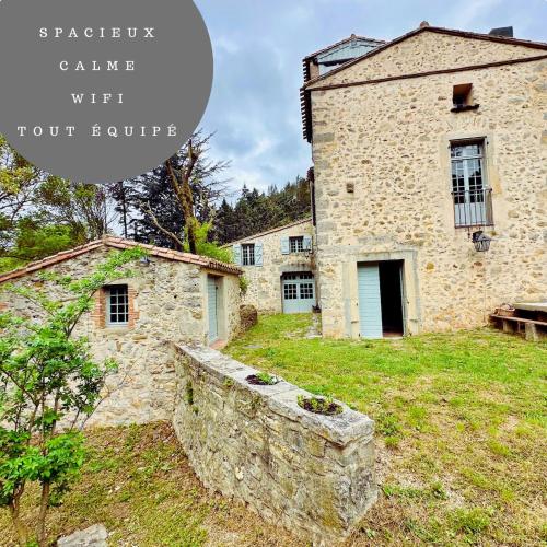 une ancienne maison en pierre avec un mur en pierre dans l'établissement Le Moulin de La Grave 450m2, à Lagrasse