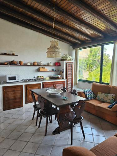 a kitchen and living room with a table and a couch at Casa DAFNE in Lipari