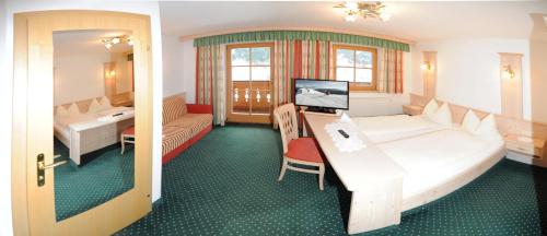 a hotel room with a large bed and a desk at Riederhof in Leogang