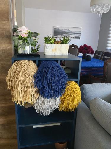 a blue dresser with colorful knitted pillows on it at 3 bedroom house close to the university, CHUL in Quebec City