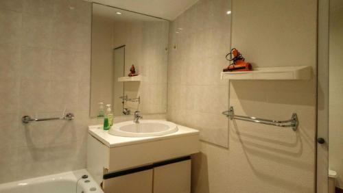 a white bathroom with a sink and a shower at Villa jean-marie in Sengouagnet