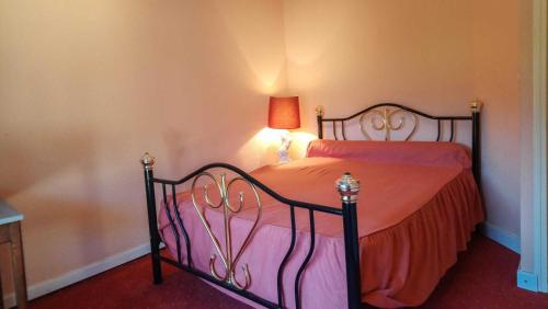 a bedroom with a bed with orange sheets and a lamp at Villa jean-marie in Sengouagnet