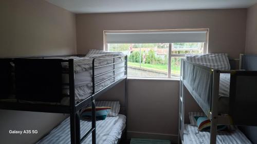 two bunk beds in a room with a window at Artisthostel Letterkenny in Letterkenny