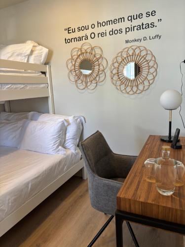 a bedroom with a bed and a table with a chair at Azores Book Hotel in Angra do Heroísmo