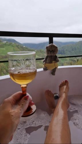 a person sitting in a bath tub with a glass of beer at Eco cottage sunrise merisi in Merisi