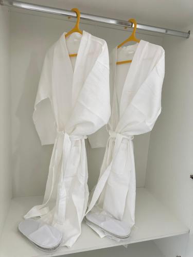 two white towels hanging on a rack in a closet at Etno Naz in Bishkek