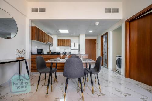 a kitchen with a table and chairs in a room at Private Beach 1BR-Yacht Club-Work Space-Pool-Gym in Ras al Khaimah