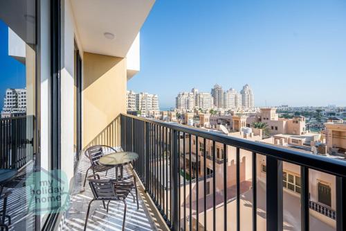 a balcony with chairs and a view of the city at Private Beach 1BR-Yacht Club-Work Space-Pool-Gym in Ras al Khaimah