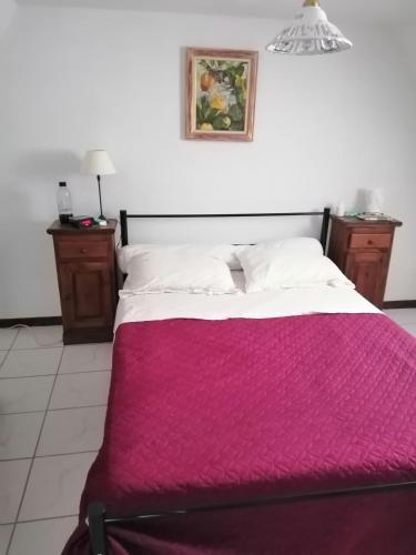 une chambre avec un lit avec une couverture rouge dans l'établissement Gîte Petit gouffre d'amour, à Padirac