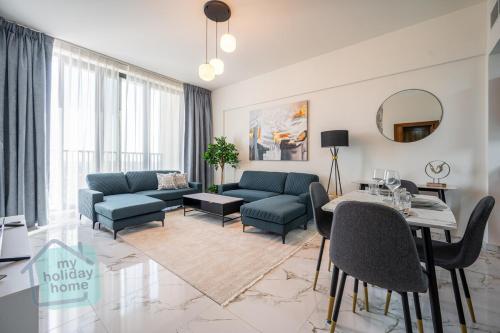 a living room with blue couches and a table at Private Beach 1BR-Yacht Club-Work Space-Pool-Gym in Ras al Khaimah