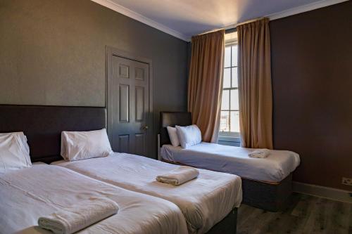 a hotel room with two beds and a window at Tron Kirk Residence in Edinburgh