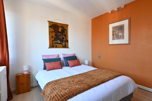 une chambre avec un grand lit aux murs orange dans l'établissement L'authentique - Hyper centre - Belle terrasse !, à Béziers