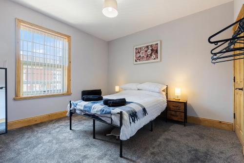 una camera da letto con un letto, un tavolo e una finestra di Pickin Cottage a Altofts