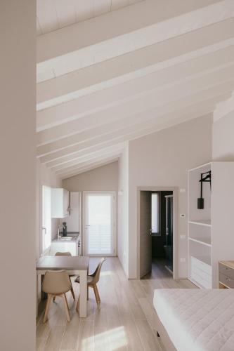 a white room with a dining room table and a kitchen at Tenuta delle Radici in Giavera del Montello