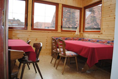 a dining room with two tables and chairs and windows at Schlummerburg in Weißkirchen in Steiermark