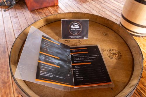 a menu on top of a wooden table at Le Galussel Gite d'étape et de séjour in Saint-Sébastien