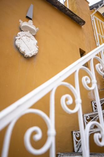 a yellow building with a white railing next to a stairs at Leone Camere D'autore - Rooftop Prince Centro Storico in Naples