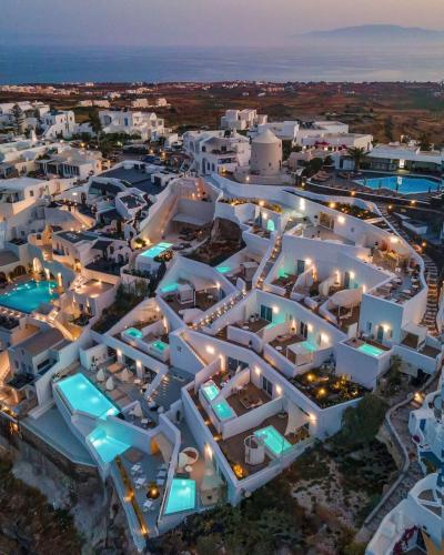 an aerial view of a large white building at night at The Saint Hotel in Oia