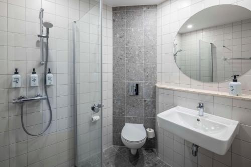 a bathroom with a shower and a toilet and a sink at Scandic Roskilde Park in Roskilde