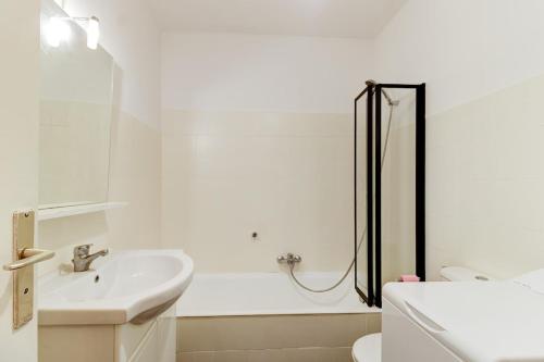 une salle de bain blanche avec un lavabo et une douche dans l'établissement Cozy Studio Apt with balcony close to Garibaldi, à Nice