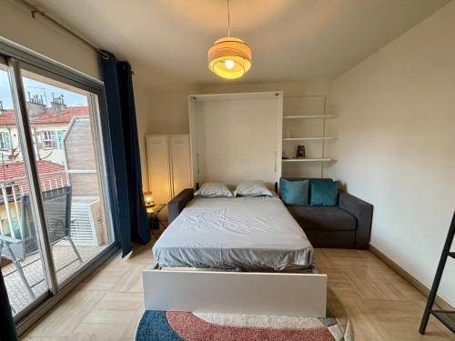 une chambre avec un lit, un canapé et une fenêtre dans l'établissement Cozy Studio Apt with balcony close to Garibaldi, à Nice