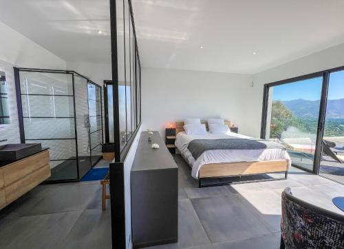 une chambre avec un grand lit et une grande fenêtre dans l'établissement Villa Panoramique, à Alata