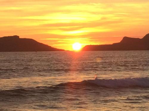 a sunset over the ocean with the sun setting at Casa Llena de Vida LB8 Alberca privada VISTA A LA BAHIA in San Carlos