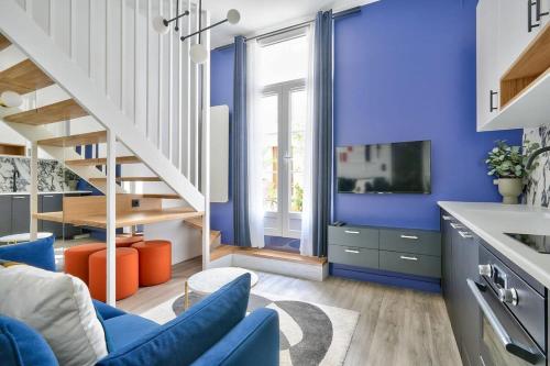 d'un salon avec des murs bleus et un escalier. dans l'établissement Studio design au coeur du Marais, à Paris