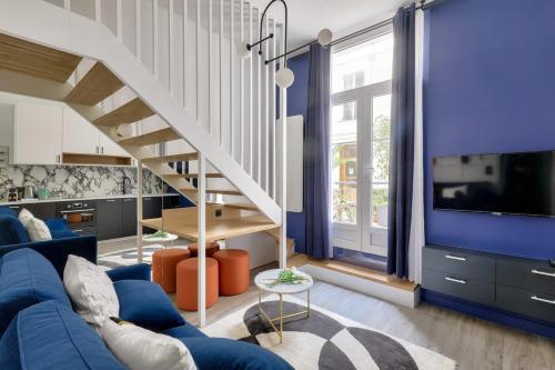 - un salon avec un canapé bleu et un escalier dans l'établissement Studio design au coeur du Marais, à Paris